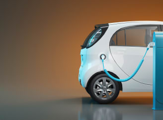 Une voiture blanche se recharge à une station de recharge bleue