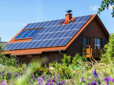 Huis met zonnepanelen in een bloemenveld