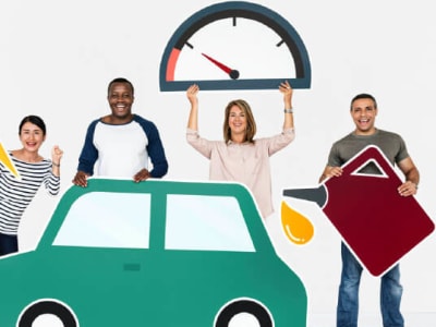 Een groep mensen (twee mannen & twee vrouwen) houden een kartonnen uitsnede van een auto / olie / gas omhoog.