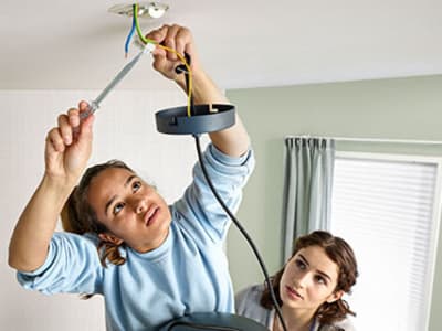 Twee vrouwen repareren een lamp