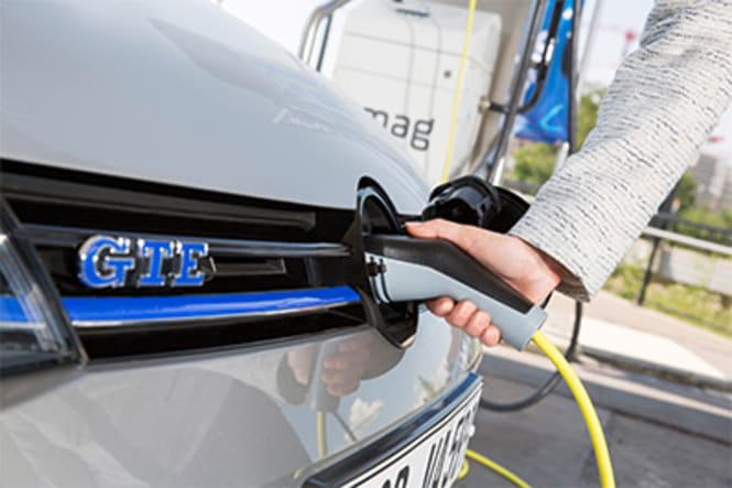 Une personne qui recharge sa voiture