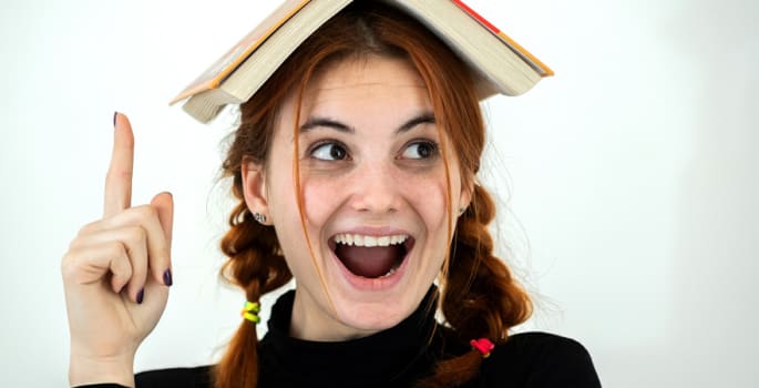 Jeune fille avec un dictionnaire sur la tête