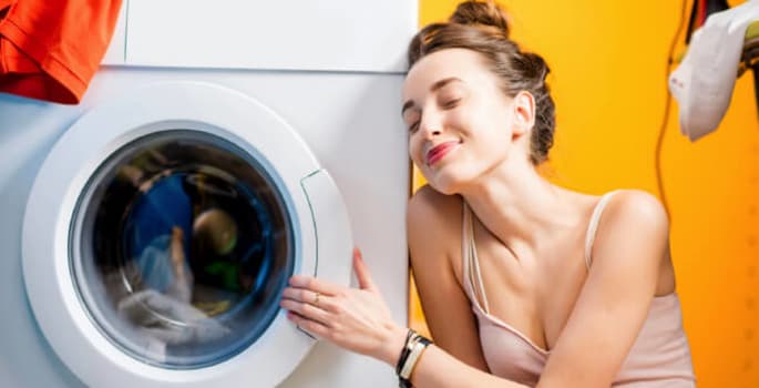 jeune femme devant son lave-linge