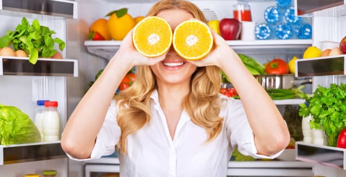 Femme heureuse devant son frigo