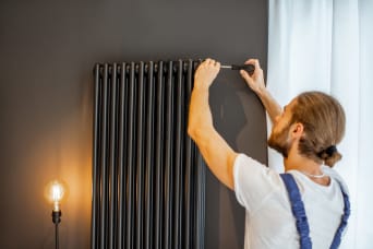 Technicien chauffage purge un radiateur