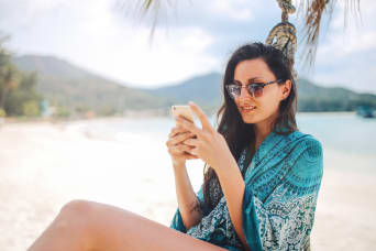 Femme sur la plage avec son smartphone