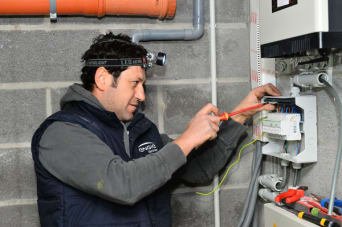 Technicien qui remplace l’onduleur d’une installation photovoltaïque