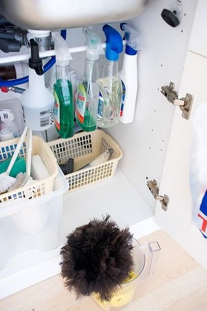 Une astuce rangement : accrocher les produits d’entretien avec vaporisateur sur une barre sous l’évier