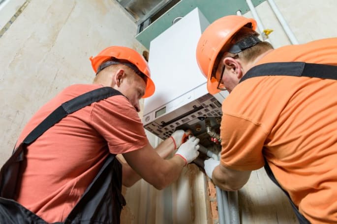 Technici installeren een nieuwe gascondensatieketel