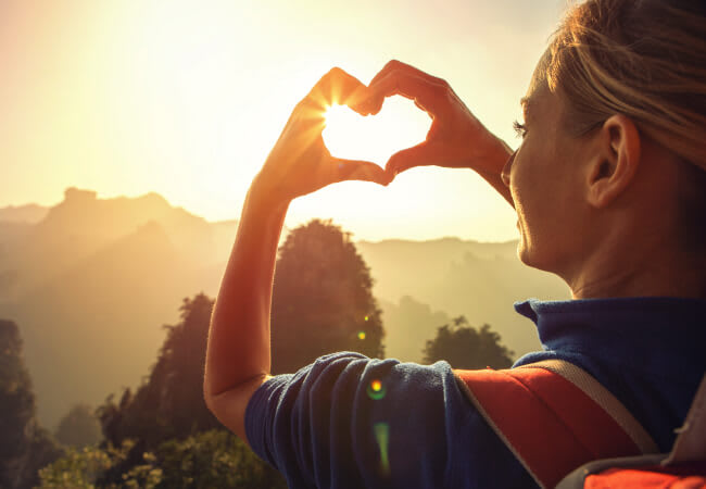 Vrouw zonsondergang hart met de vingers