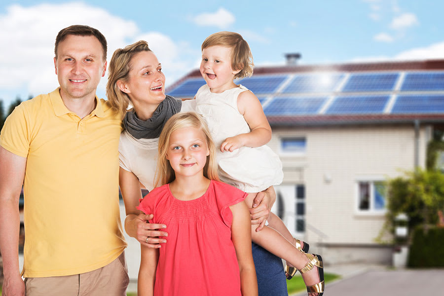 Gezin voor een woning met zonnepanelen